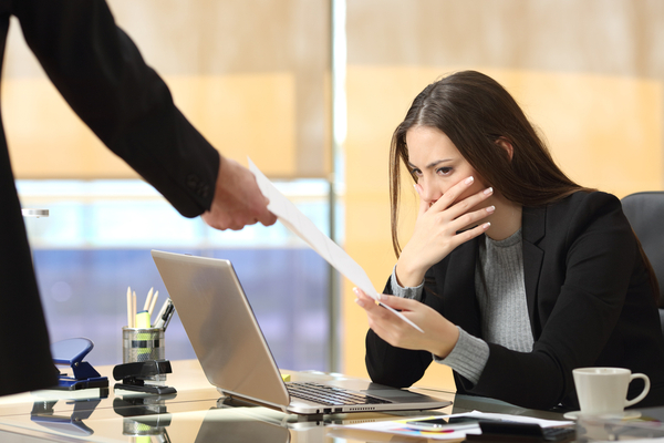 Worried businesswoman receiving a notification from a colleague in her office 